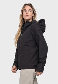 Schwarze wasserdichte Jacke mit Kapuze, Frontreißverschluss und Seitentaschen. Hergestellt aus einem glatten Textilgewebe, entworfen für den Outdoor-Einsatz.