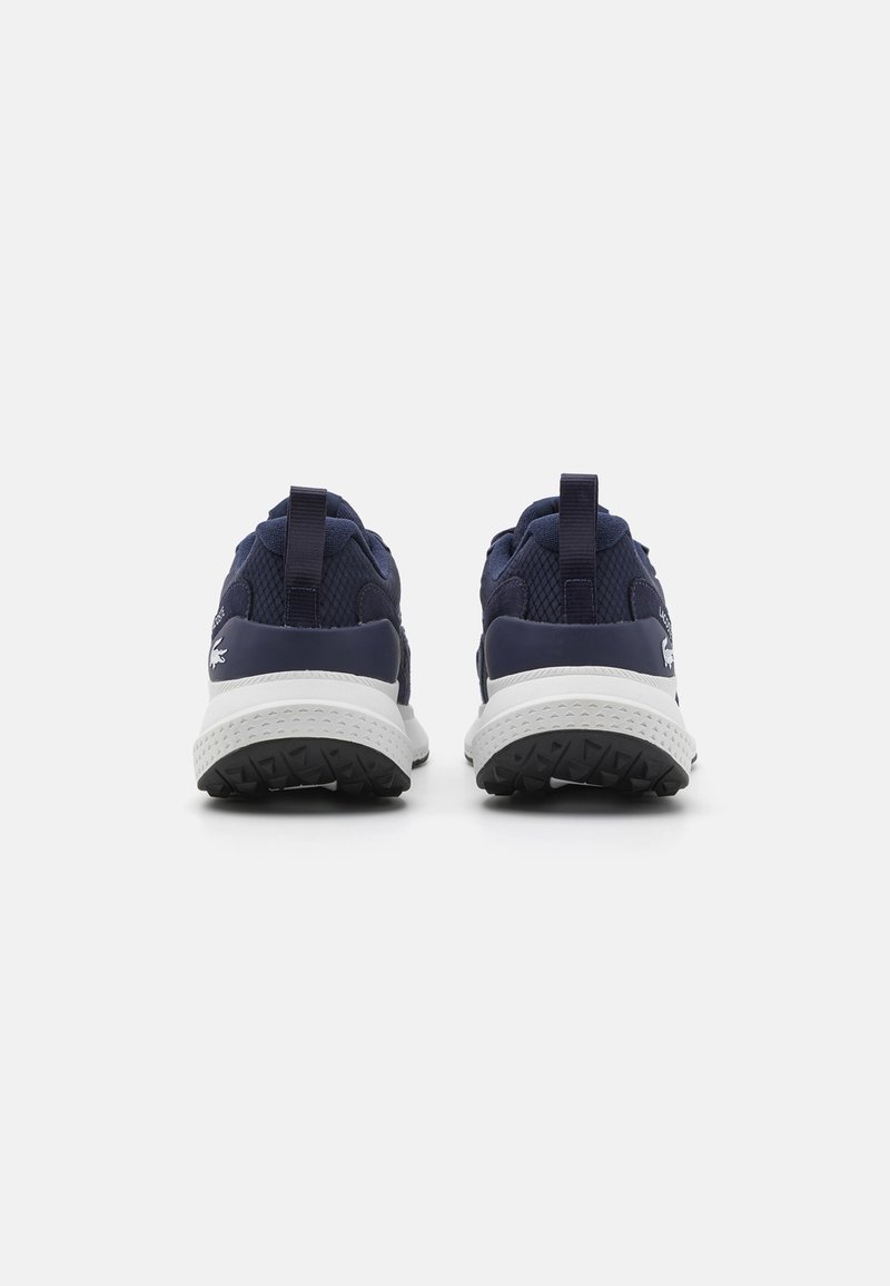 Marine sportchoenen met mesh-accenten, witte zolen en zwarte gestructureerde buitenzolen. Voorzien van trekhaakjes op de hiel voor eenvoudig aantrekken.