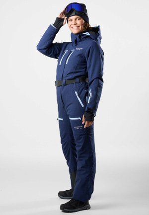 Marine skikostuum met blauwe accenten, ritszakken, verstelbare riem en capuchon. Inclusief handschoenen en goggles, vervaardigd uit weerbestendig materiaal.