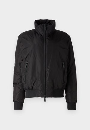 Giacca a vento nera con colletto alto, chiusura con zip frontale e due tasche laterali con zip. Presenta polsini elastici e un design corto.