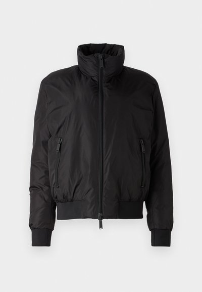 Veste doudoune noire avec un col haut, fermeture éclair à l'avant et deux poches latérales zippées. Comprend des poignets élastiques et un design court.