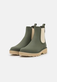Stivali alla caviglia in gomma verde con pannelli laterali beige, suole in gomma texturizzata e linguette per una facile calzata. Superficie liscia con design a punta arrotondata.