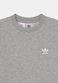 Gray sweatshirt with a round neckline, made of textured fabric. Features a white Adidas logo on the left chest area.