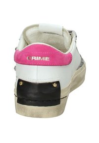 Sneaker bianco con un accento in suede rosa sul tallone, parte inferiore nera e hardware dorato. Presenta un design testurizzato e una collo imbottito.