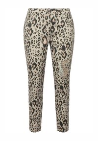 Pantalons façon léopard en beige, avec des taches noires et orange. Coupe slim avec poches avant et un motif tigre sur le côté.