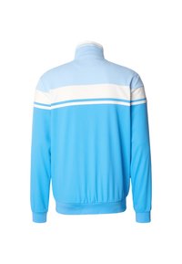 Lyseblå glidelåsjakke med høy hals, hvite og blå horisontale striper over øvre del av ryggen, og elastiske mansjetter og kant.