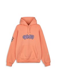 Sudadera melocotón con cordones, gran logo "GRIMEY" en púrpura, bolsillo frontal tipo canguro y detalle gráfico en la manga izquierda. Material suave, corte oversize.