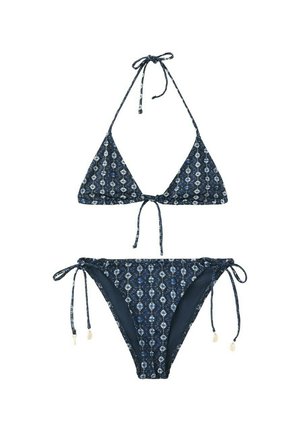 Bikini azul marino con patrones geométricos en blanco y azul, top de triángulo con cuello halter y lazos, bragas a juego con lazos en los costados y pequeños detalles de conchas.