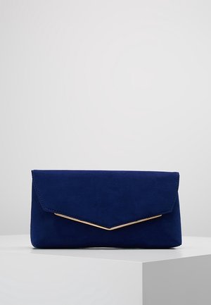 Blue suede envelope clutch bag with gold trim along the flap edge, displayed on a white pedestal against a gray background.