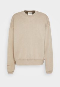 Felpa beige con texture a coste, collo rotondo e spalle scese. Presenta un ricamo discreto del logo sulla manica.
