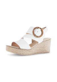 White wedge sandals with a woven jute platform, cross-strap design, and a circular wooden accent on the adjustable strap.