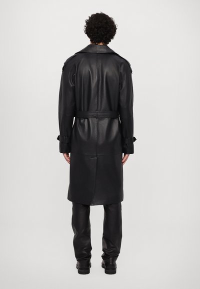 Svart läder trench coat med bälte i midjan, långa ärmar och axelremmar; slät struktur och knälång design.