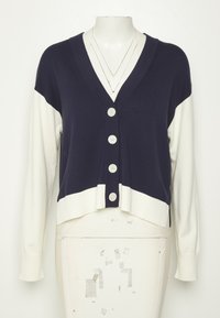 Marinblå och vit kortärmad cardigan med djup V-ringning, långa ärmar, femknäpps stängning samt stickad kant nertill och vid ärmsluten.