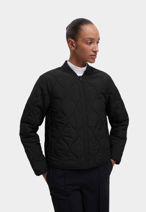 Sort quiltet jakke med opretstående krave og lynlåslukning, med rundede mønstersyninger og lange ærmer. Glat tekstur.