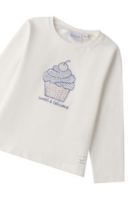 Camiseta blanca de manga larga con un diseño de cupcake azul con una cereza, texto "dulce y delicioso" y pequeños acentos decorativos.
