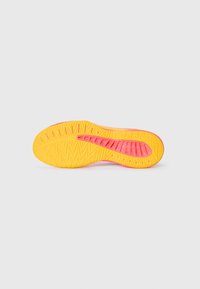 Shoe outsole in yellow with pink accents, featuring a textured pattern for grip and flexibility. Curved heel and defined traction grooves present.
