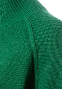Grüner gestrickter Pullover mit gerippter Textur am Kragen und an den Schultern, der einen glatten Körper mit subtilen Variationen im Gewebe zeigt.