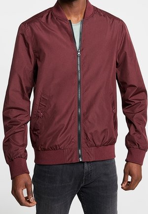 Burgunderfarbene Bomberjacke aus leichtem Stoff, mit einem Reißverschluss vorne, geripptem Kragen und Manschetten sowie Seitentaschen.