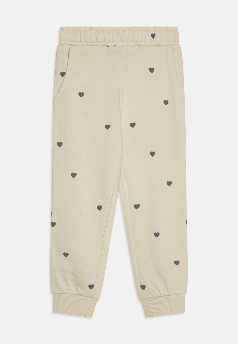 Beige joggings met een elastische tailleband, voorzien van een verspreid donkergrijs hartpatroon, twee zijzakken en geribbelde enkels.
