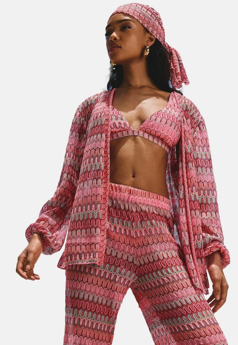 Roze gepatroneerde driekleurige outfit met een cropped top, een lange mouwen cardigan met gerimpelde manchetten en bijpassende broeken.