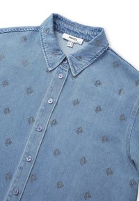 Camicia in denim blu con colletto, caratterizzata da motivi metallici ricamati e chiusura frontale con sei bottoni, con una texture morbida e un design casual.