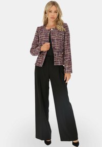 Fioletowo-biała kurtka z tweedu z okrągłym kołnierzem, dwiema guzikami i kieszeniami z przodu, noszona na czarnej bluzce i spodniach. Gładka tekstura z ustrukturyzowanym krojem.