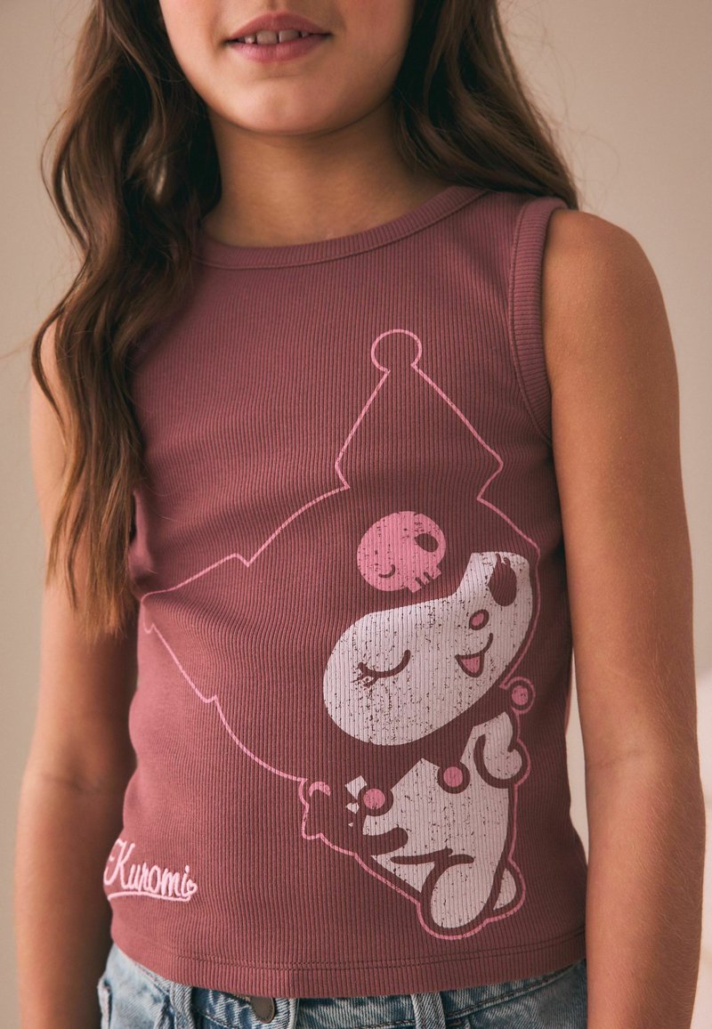 Jeune fille portant un haut sans manches mauve avec un joli personnage de dessin animé blanc et rose et le mot « Kuromi » en bas.