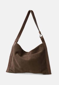 Borsa a tracolla in suede marrone con parte superiore curva, texture liscia e base piatta. Dotata di una tracolla in pelle lunga e regolabile.