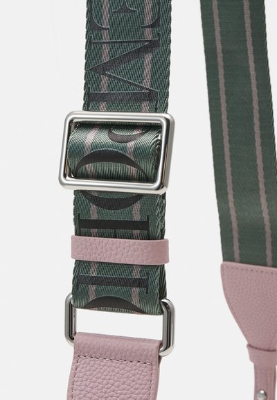 Verstelbare strap met een groen geweven ontwerp, zwarte letters, roze leren accenten en zilveren metalen hardware. Geribbelde oppervlakte.