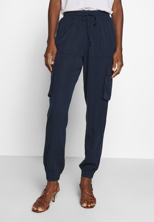 Pantalones cargo azul marino con puños elásticos, cintura con cordón ajustable y dos bolsillos laterales. Tejido ligero con textura suave.