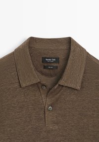 Hnědá lněná polokošile s límečkem, dvěma knoflíky a černou štítkem s nápisem "Massimo Dutti, Vyrobeno v Kambodži, 100 % len."