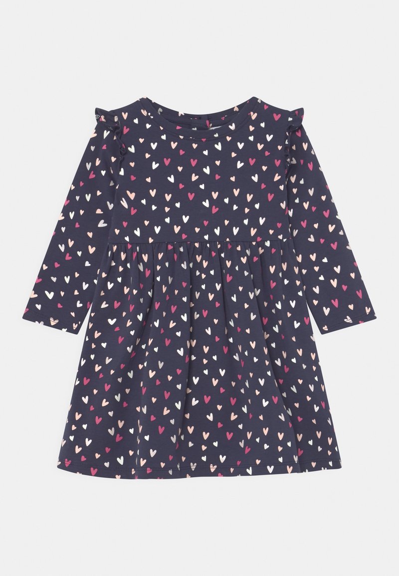 Granatowa sukienka na długi rękaw z wzorem serduszek w kolorach różowym, białym i czerwonym. Posiada marszczoną spódnicę i falbanki na ramionach. Wykonana z bawełny.