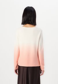 Gebreide trui met een ombré ontwerp, dat overgaat van wit naar lichtroze, met een ronde halslijn en lange mouwen.
