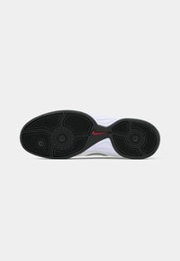 Sola de sapato atlético em preto e branco com um padrão texturizado, apresentando um proeminente logótipo em vermelho da swoosh na lateral.