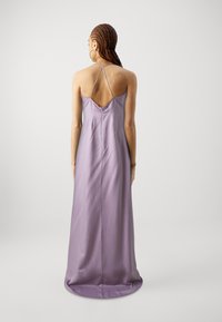 Rochie maxi din satin purpuriu, cu spatele jos și bretele subțiri încrucișate. Textură netedă și lungime completă, cu o croială lejeră.
