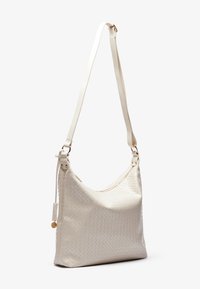 White woven leather handbag with a curved shape, adjustable shoulder strap, and gold-tone hardware. Features a zip closure and textured surface.
