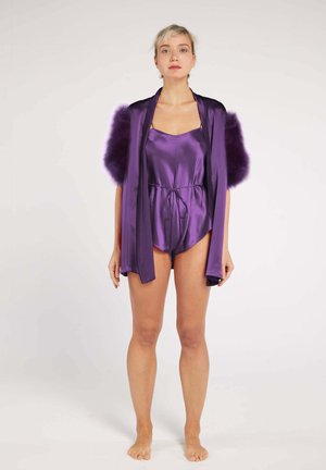 Purple satin bodysuit with a tie waist, paired with a matching long cape featuring plush purple fur accents on the shoulders.