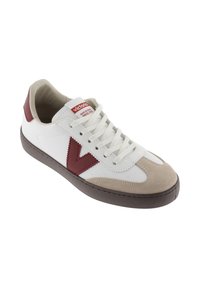 Sneaker bianco con accenti bordeaux e punta in suede beige. Presenta un'etichetta con logo rosso e lacci bianchi. Suola in gomma, forma arrotondata.
