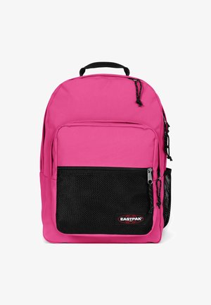 Pink backpack with a black mesh front pocket, durable fabric, zip closures, and a top handle. Features adjustable shoulder straps.
