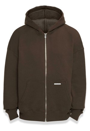 Felpa con zip marrone realizzata in morbido tessuto. Presenta un cappuccio spazioso, tasche frontali, polsini a coste e una piccola etichetta vicino all'orlo.