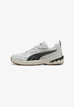 White mesh athletic shoe with black accents, textured overlays, and a rubber sole. Features a cushioned collar and lacing system.
