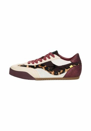 Zapatilla deportiva de perfil bajo con paneles beige, blancos, burdeos y brillantes, cordones burdeos y un detalle de estampado de leopardo en el lateral.