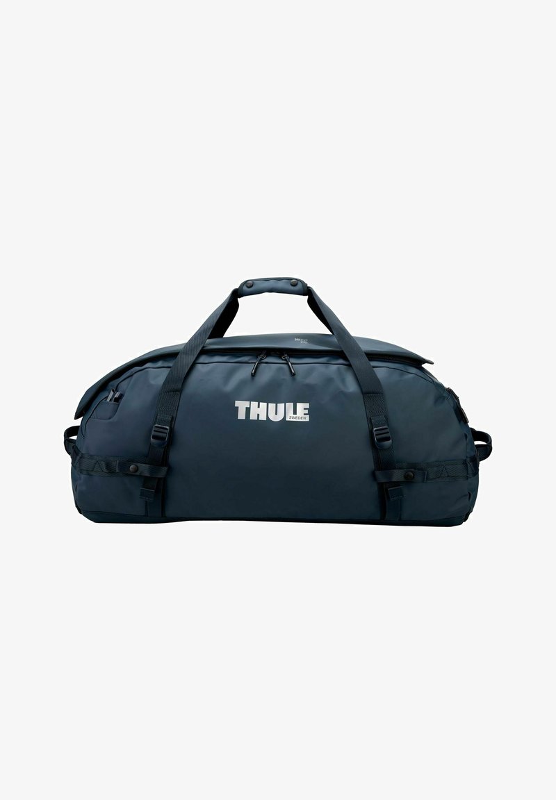 Grand sac polochon Thule bleu foncé avec double sangle de transport et compartiment principal zippé sur fond blanc.