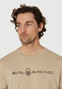 Sail Racing BOWMAN TEE - Triko s potiskem - dry sand
