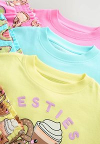 Fyra bomullssweatshirts med rund hals i gult, rosa, ljusblått och mönstrad tyg som har tecknade matgrafik och broderad text.