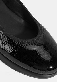 Zwarte ballerina's met een gestructureerde, glanzende lakafwerking, een ronde neus en een elastische rand voor een veilige pasvorm. Rubberen zool.