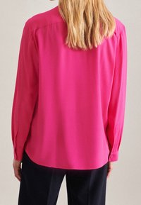 Camicia a maniche lunghe rosa realizzata in tessuto morbido, con vestibilità comoda, polsini abbottonati e orlo arrotondato. La vista posteriore non presenta dettagli aggiuntivi.