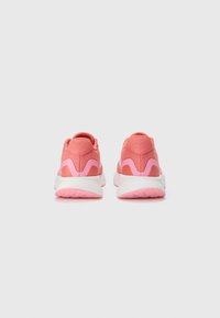 Pink athletic shoes with a textured upper, contrasting accents, and a white midsole. Rounded heel and patterned rubber outsole.