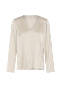 Blouse beige à manches longues avec encolure en V, tissu lisse et léger détail de couture centrale sur un fond blanc uni.