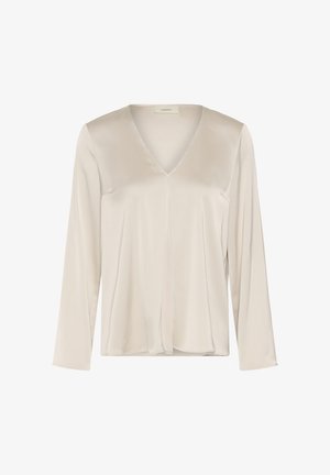 Beżowa bluzka z długim rękawem z dekoltem w serek, gładka tkanina i delikatny szew wzdłuż środka, na jednolitym białym tle.